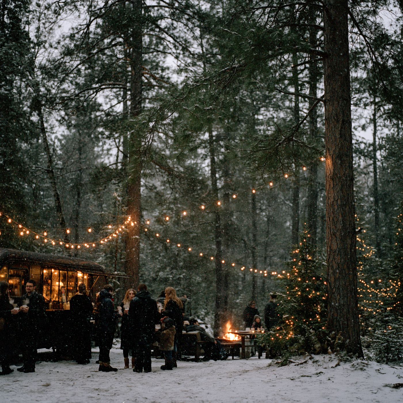 Evening winter gathering around the coffee truck under string lights in a snowy Minnesota forest